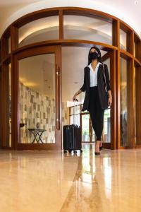 a woman standing in a room with a suitcase at Park Hyatt Chennai in Chennai