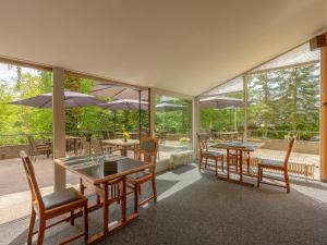 a restaurant with tables and chairs and windows at Paulshöhe in Waren