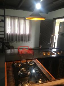 a kitchen with a stove top and a sink at Linda casa na Gamboa Garopaba in Garopaba