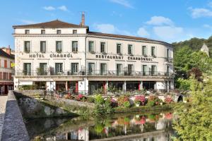 ein großes weißes Gebäude neben einem Fluss in der Unterkunft Hotel Restaurant Charbonnel in Brantôme