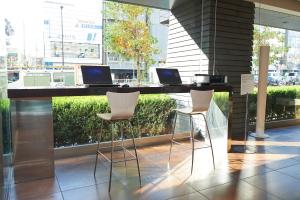 a desk with two laptops on it with two chairs at Sotetsu Fresa Inn Higashi Shinjuku in Tokyo