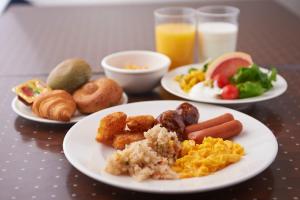 three plates of breakfast food on a table at Sotetsu Fresa Inn Higashi Shinjuku in Tokyo