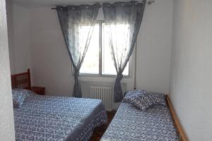 une chambre avec deux lits et une fenêtre dans l'établissement Bel appartement face à la mer 20min de port aventura, à Miami Platja