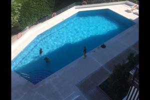 uma vista sobre uma grande piscina azul em Bel appartement face à la mer em Miami Platja