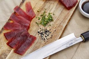 a cutting board with a piece of meat and a knife at Hotel Punta Sur in Tarifa