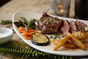 a plate of meat and french fries on a table at Hotel Punta Sur in Tarifa