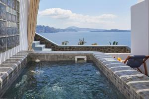 - un bassin profond dans une maison avec vue sur l'eau dans l'établissement Luxury Santorini Villa Superior Cave Villa Outdoor Hot Tub Oia, à Oia