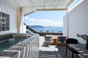 une maison avec une piscine et une vue sur l'océan dans l'établissement Luxury Santorini Villa Superior Cave Villa Outdoor Hot Tub Oia, à Oia