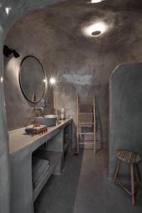La salle de bains est pourvue d'un lavabo et d'un miroir. dans l'établissement Luxury Santorini Villa Superior Cave Villa Outdoor Hot Tub Oia, à Oia
