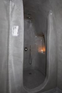 La salle de bains est pourvue d'une douche et d'un miroir. dans l'établissement Luxury Santorini Villa Superior Cave Villa Outdoor Hot Tub Oia, à Oia