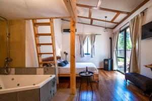 a bedroom with a bed and a bathtub and a tub at Gate Away B&B Units - המקום באל רום in El-Rom