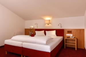 a bedroom with a large bed with a red headboard at Hotel Garni Maria Theresia in Sölden