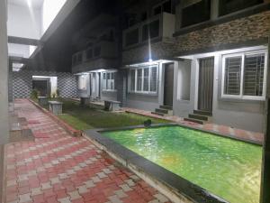 uma piscina em frente a um edifício à noite em La Villa Beach Paradise em Mahabalipuram