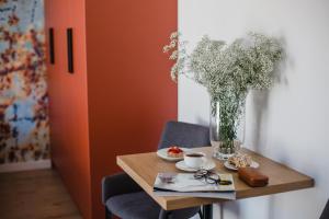W&K Apartments - Ginger Suite في كوشالين: طاولة صغيرة مع إناء من الزهور والأكواب