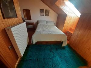 - une petite chambre avec un lit et un tapis vert dans l'établissement Tzoumerka, à Ktistádes