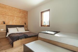 a bedroom with two beds and a window at Chalet Vrhovi Kopaonika in Kopaonik
