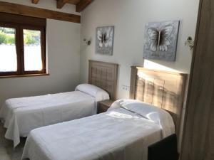 a room with two beds and a window at EL CARLOTO in La Población