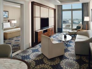 a living room filled with furniture and a large window at Grand Plaza Mövenpick in Dubai
