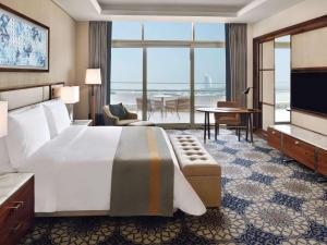 a hotel room with a bed and a view of the ocean at Grand Plaza Mövenpick in Dubai