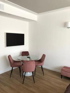 comedor con mesa, sillas y TV en A&F Apartment Padova Piazza Garibaldi en Padova