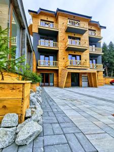 un gran edificio de apartamentos con un patio de piedra en Chalet Vrhovi Kopaonika en Kopaonik