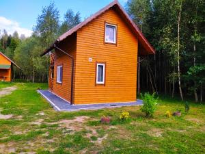 ein kleines Haus inmitten eines Gartens in der Unterkunft Domek letniskowy Szramowo in Zbiczno