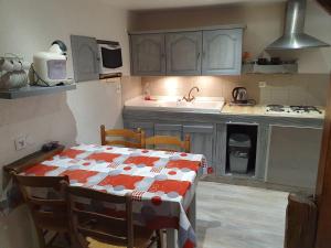 a kitchen with a table with a red and white table cloth at Les Plumes in Asnans