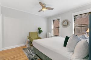 1 dormitorio blanco con 1 cama y ventilador de techo en 1BR Lively & Rejuvenating Apt in Prime Location - Roscoe 2M, en Chicago