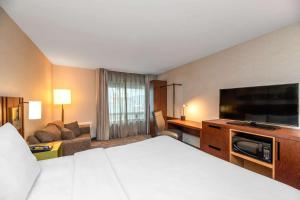 a hotel room with a bed and a flat screen tv at Comfort Inn Boucherville in Boucherville