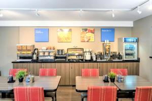 restauracja z dwoma stołami i krzesłami oraz ladą w obiekcie Comfort Inn Boucherville w mieście Boucherville