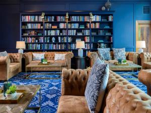 a living room with couches and bookshelves at Shearwater Hotel & Spa in Ballinasloe