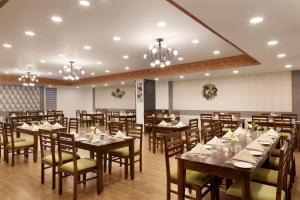 斋浦尔Click Hotel Jaipur, Raja Park的用餐室配有木桌和椅子