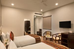 ein Hotelzimmer mit 2 Betten und einem TV in der Unterkunft Click Hotel Jaipur in Jaipur