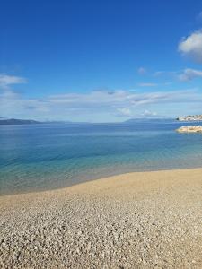 a sandy beach with the ocean in the background at Apartments Klaricic in Živogošće