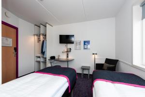 a hotel room with two beds and a television at Cabinn Aalborg in Aalborg