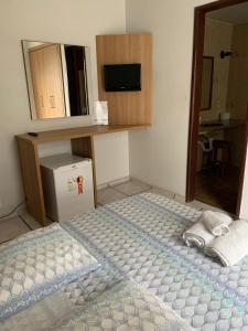 1 dormitorio con 1 cama con 2 toallas en Pousada Marissol, en Cabo Frío