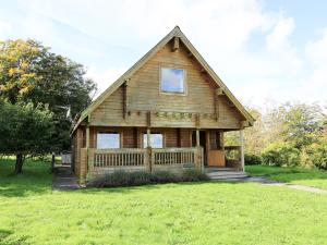 Casa de madera con porche en un campo de césped en Pen Y Clawdd, en Presteigne