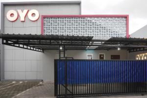 aiya sign on the side of a building with a blue gate at OYO 90033 DeHome Family in Yogyakarta