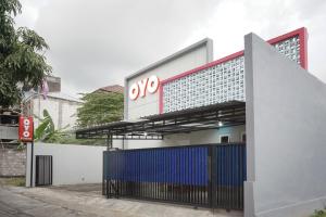 a building with an ovs sign on the side of it at OYO 90033 DeHome Family in Yogyakarta