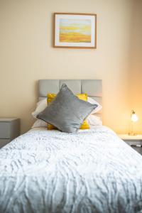 ein Schlafzimmer mit einem weißen Bett und gelben Kissen in der Unterkunft Apartment 4 in Worksop