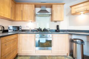 a kitchen with wooden cabinets and a stove top oven at Apartment 4 in Worksop