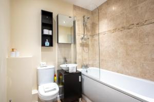 a bathroom with a toilet and a sink and a shower at Apartment 4 in Worksop
