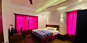 um quarto com cortinas cor-de-rosa e uma cama num quarto em White Shell Beach House em Cananor