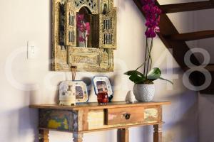 a table with a mirror and flowers on it at Beach House - Camburi in Camburi