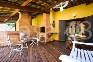 eine Terrasse mit Tisch und Stühlen und einem Kamin in der Unterkunft Beach House - Camburi in Camburi