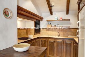 una cocina con armarios de madera y un bol en una encimera en Casa Er Os by Totiaran en Baqueira-Beret
