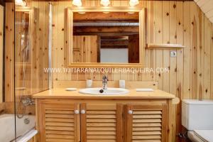 a bathroom with a sink and a mirror and a toilet at Casa Er Os by Totiaran in Baqueira-Beret