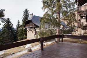 un puente de madera frente a una casa en Casa Er Os by Totiaran en Baqueira-Beret