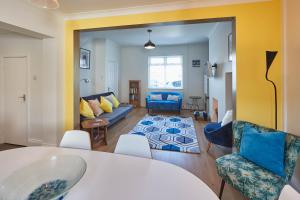 sala de estar con mesa, sillas y sofá en Host & Stay - Artist House, en Loftus
