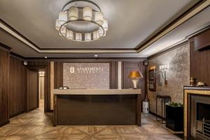 a lobby with a reception desk and a chandelier at Cityhotel Apartments in Kyiv